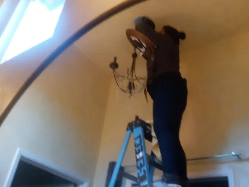 Electrician installing a chandelier in a Norwalk residence